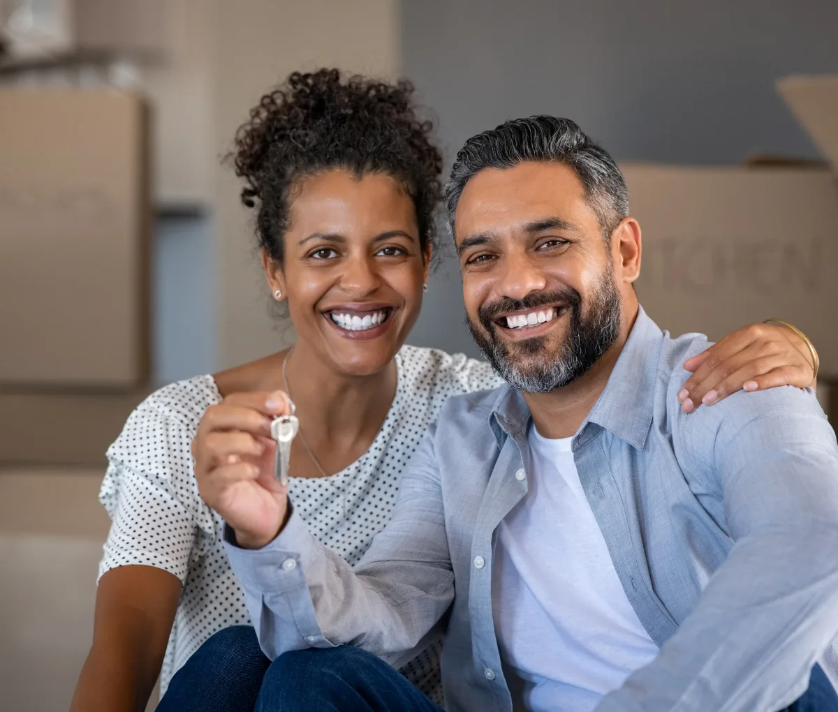 Couple with keys to their new home after tracking loans and EMIs